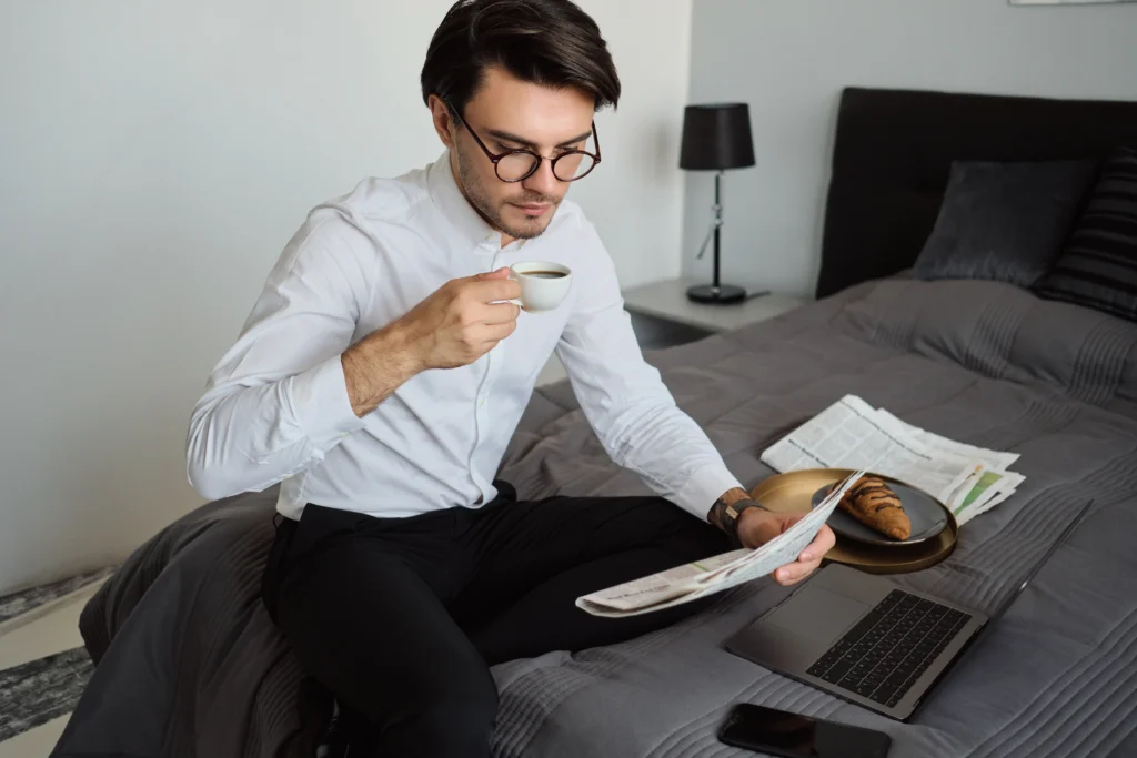 A CEO reading newspaper while having coffee.