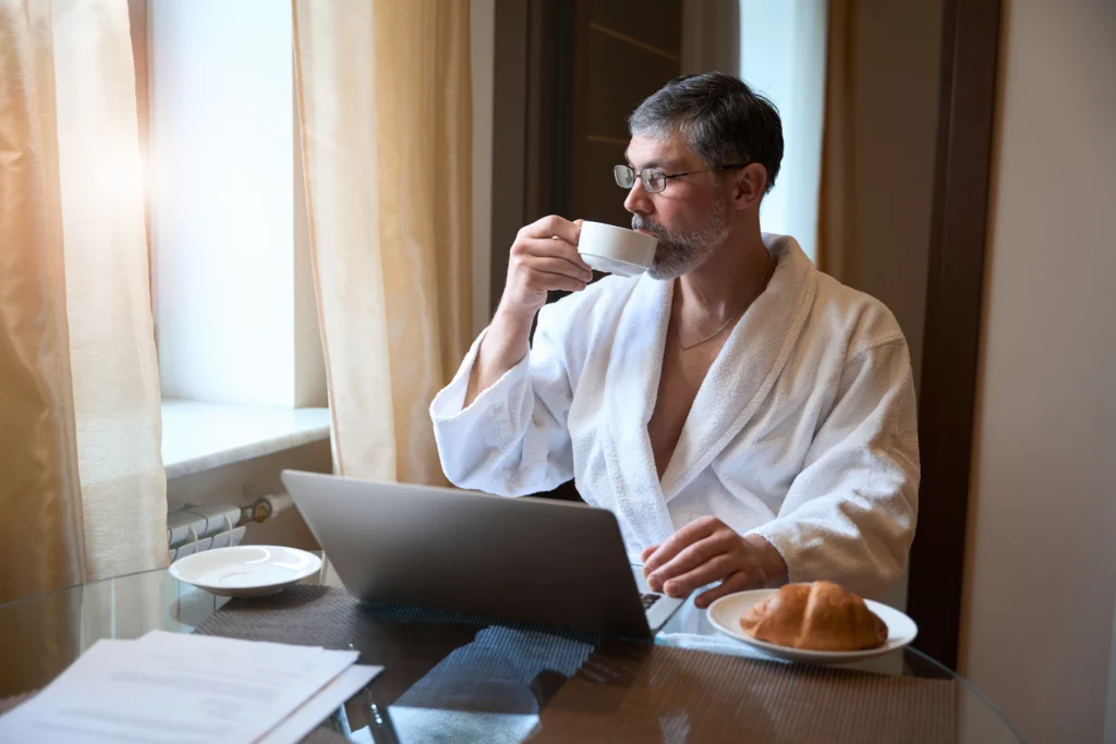 A CEO Drinking coffee while wprking on Laptop